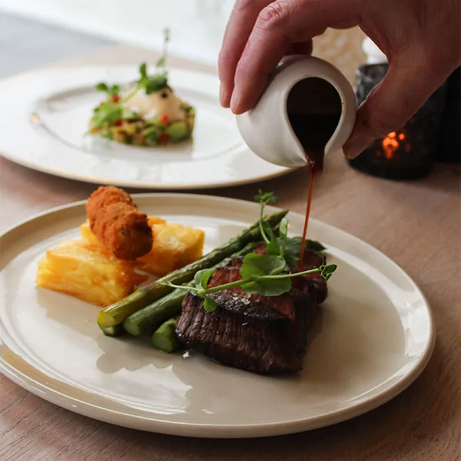 Chef van Restaurant Sophia die een gerecht opdient