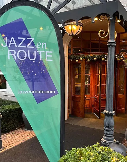 Ingang van het Carlton Ambassador Hotel met een Jazz en Route vlag